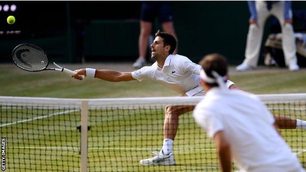 Novak Djokovic stretches for a forehand in his Wimbledon win over Roger Federer