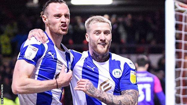 Will Keane celebrates Wigan's second goal at Crewe