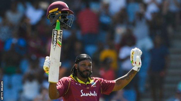 West Indies opener Chris Gayle lifts his helmet on the handle of his bat and waves to the crowd in celebration of his half-century against England in the fifth ODI