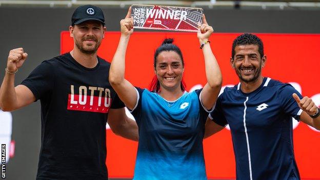 Ons Jabeur of Tunisia poses with the Berlin trophy alongside husband Karim Kamoun and coach Issam Jellali