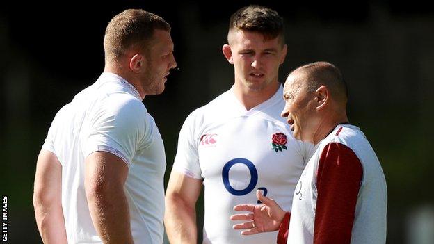 Eddie Jones the England head coach talks to Sam Underhill and Tom Curry during a training session