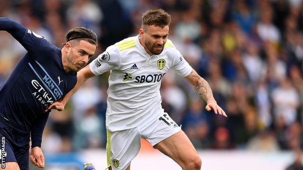 Leeds United's Stuart Dallas and Manchester City's Jack Grealish tussle for the ball