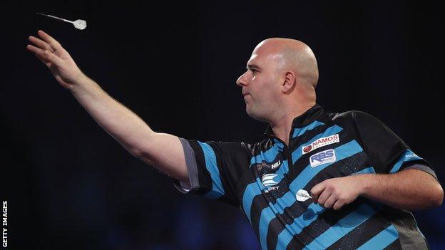 Rob Cross throws dart