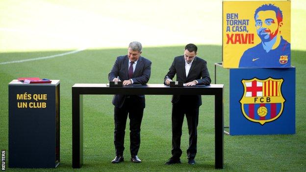 Xavi signed his contract on the pitch at the Nou Camp alongside Barcelona president Joan Laporta