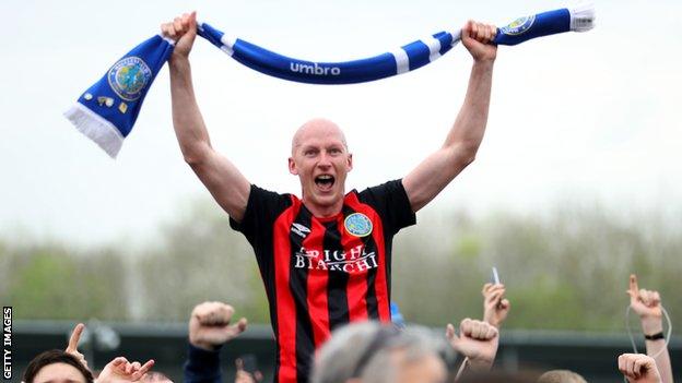 Danny Whittaker is carried aloft by Macclesfield fans after promotion