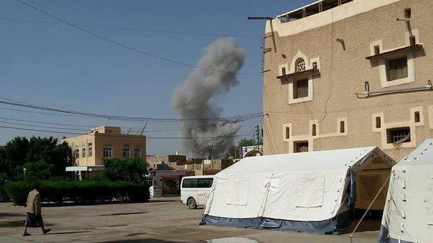 The aftermath of an air strike in the background of the al-Jumhori hospital, on the right