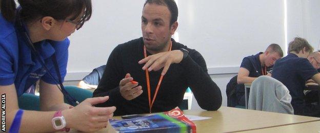 Fahd Saleh in class, talking to tutor Rachael Evans