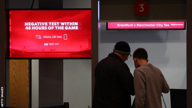 Messages on the screen at the ticket office reminding fans to get their NHS Covid pass or negative lateral flow test ready ahead of the Premier League match between Brentford and Manchester City