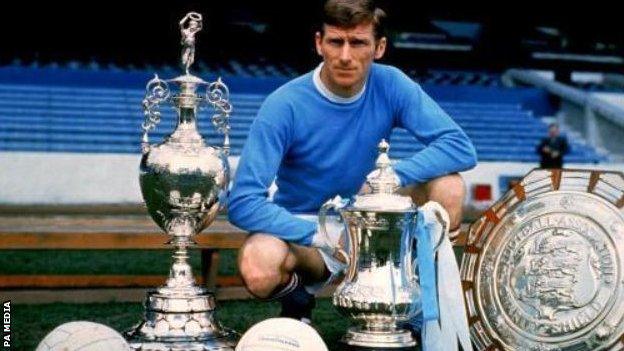 Tony Book kneeling with the league trophy, Charity Shield and FA Cup