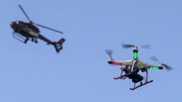 Quadcopter with police helicopter in the background