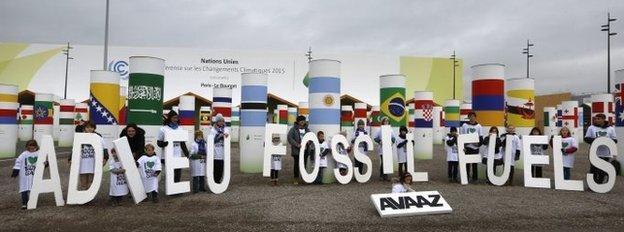 Children display giant letters reading "Adieu (Bye) Fossil Fuels", during the COP21 World Climate Change Conference