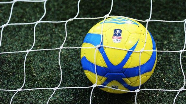 A football resting in a goal net