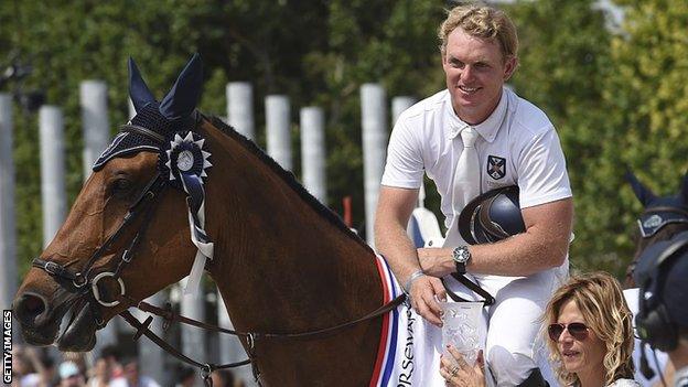 Jamie Kermond receives his trophy after winning the High Jumping event of the second edition of the Paris Eiffel Jumping tournament on the Champ de Mars in Paris on 3 July, 2015