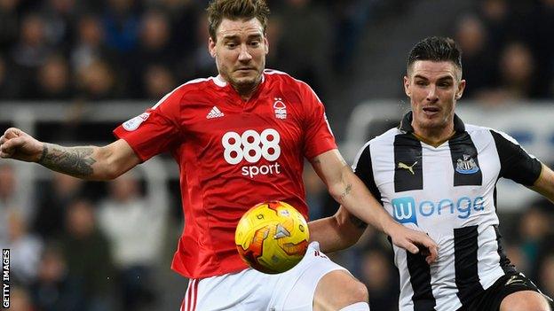 Nicklas Bendtner (l) challenges Ciaran Clark of Newcastle