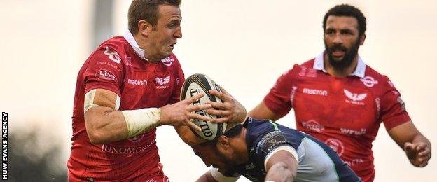 Hadleigh Parkes is tackled by Bundee Aki during a match between Scarlets and Connacht