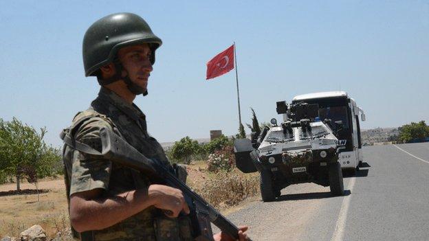 A Turkish soldier stands guard at a border crossing with Syria