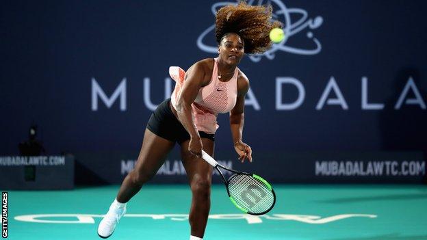 Serena Williams serves during her exhibition match against sister Venus in Abu Dhabi