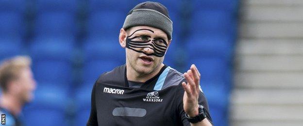 Glasgow Warriors fly-half Finn Russell wears a protective mask during training