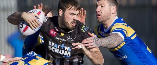 Widnes' James Chapelhow is tackled against Leeds