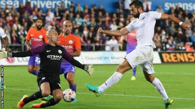 Jordi Amat is challenged by Manchester City goalkeeper Willy Caballero