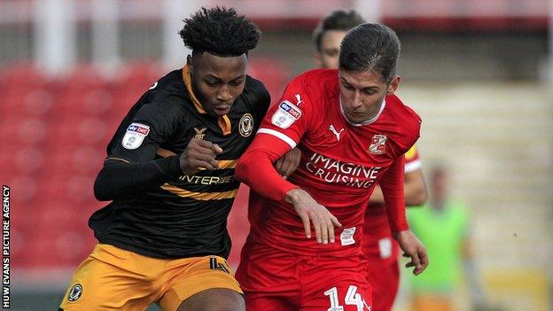 Antoine Semenyo of Newport County and Ellis Iandolo of Swindon Town battle for the ball