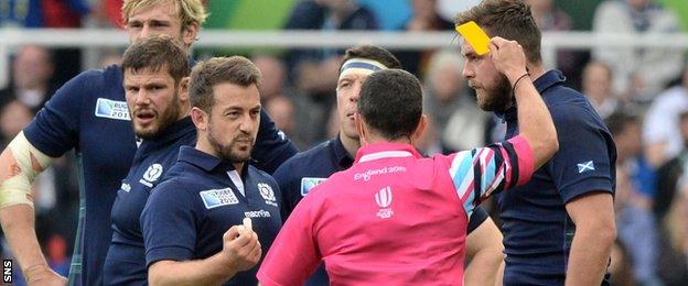 Scotland's Ryan Wilson is shown yellow by referee Jaco Peyper