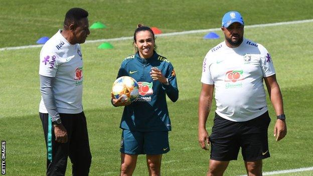 Marta, pictured with two Brazil coaches