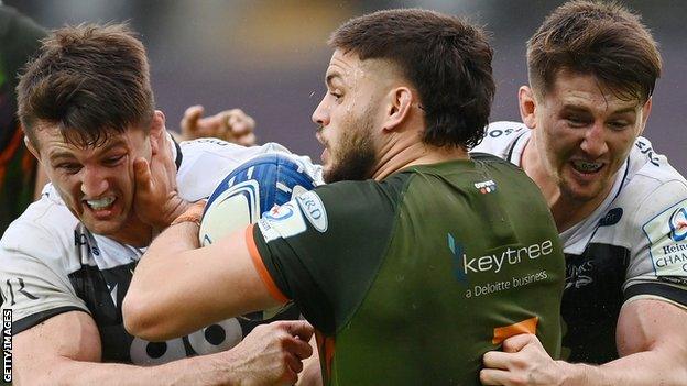 Ethan Roots of Ospreys is tackled by Tom Curry and Ben Curry of Sale Sharks