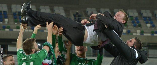 Northern Ireland manager Michael O'Neill is thrown in to the air by players