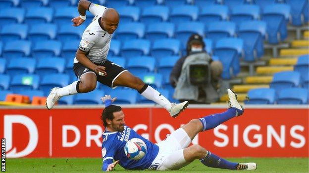 Cardiff captain Sean Morrison makes a sliding challenge on Swansea's Andre Ayew