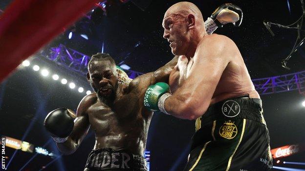 Tyson Fury punches Deontay Wilder