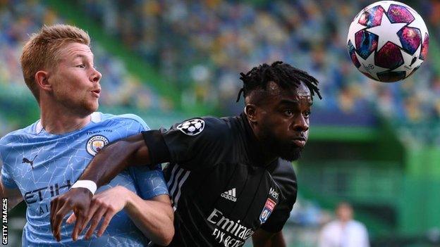 Maxwel Cornet challenges Manchester City's Kevin de Bruyne for the ball