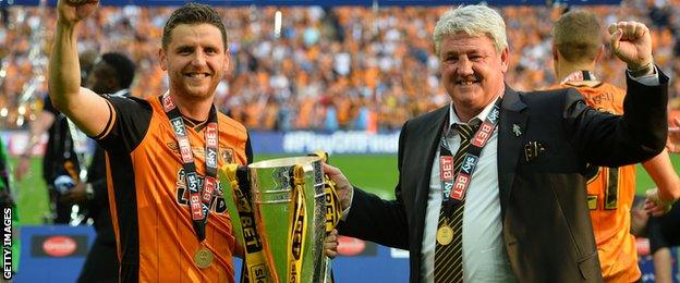 Steve Bruce holds the Championship Play-off Final Trophy aloft with his son, centre-half Alex Bruce