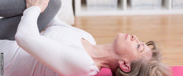 older woman doing exercise on the floor