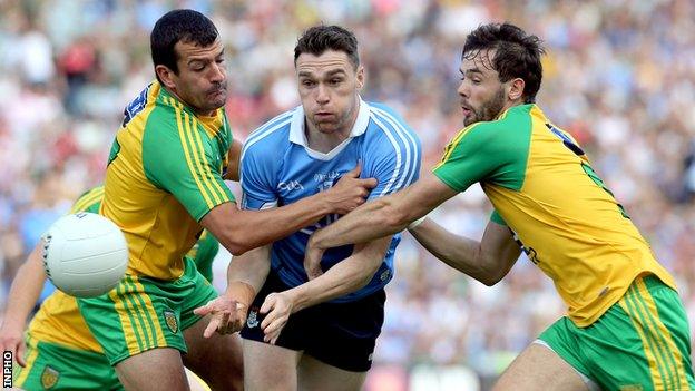 Paddy Andrews is tackled by Frank McGlyn and Odhran Mac Niallais