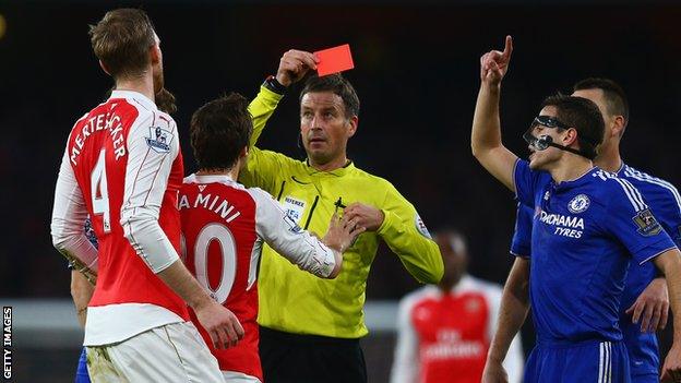 Mark Clattenburg shows Per Mertesacker a red card