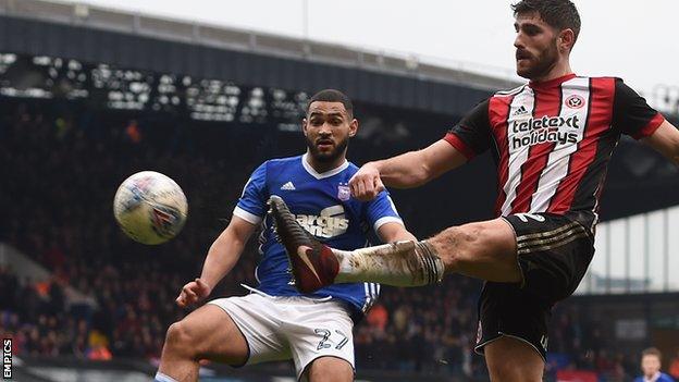 Sheffield United's Ched Evans (right) crosses the ball under pressure from an Ipswich Town defender