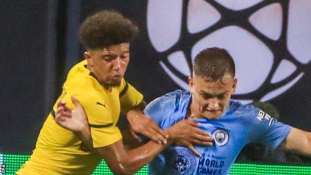 Jadon Sancho (left) wrestles for the ball with Luke Bolton