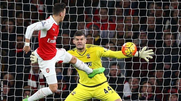 Fraser Forster saves a shot from Mesut Ozil