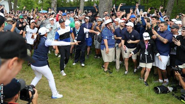 Brooks Koepka takes a shot surrounded by the crowd at Bethpage