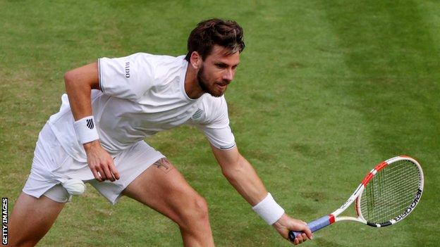 Cameron Norrie bends for a return in