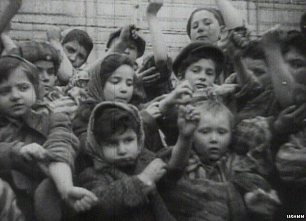 Children at Auschwitz show the identification numbers printed on their arms