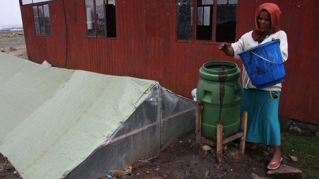 Zenebech Alemayehu mixing cow dung with water to add to her digester