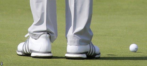 Dustin Johnson stands next to his ball on the fifth hole