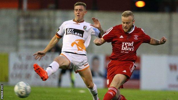 Glentoran's Jonathan Smith and Mark Shannon of Ballyclare challenge for the ball at Dixon Park