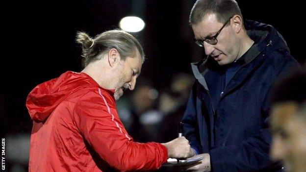 Robbie Savage signs an autograph before playing for Stockport Town