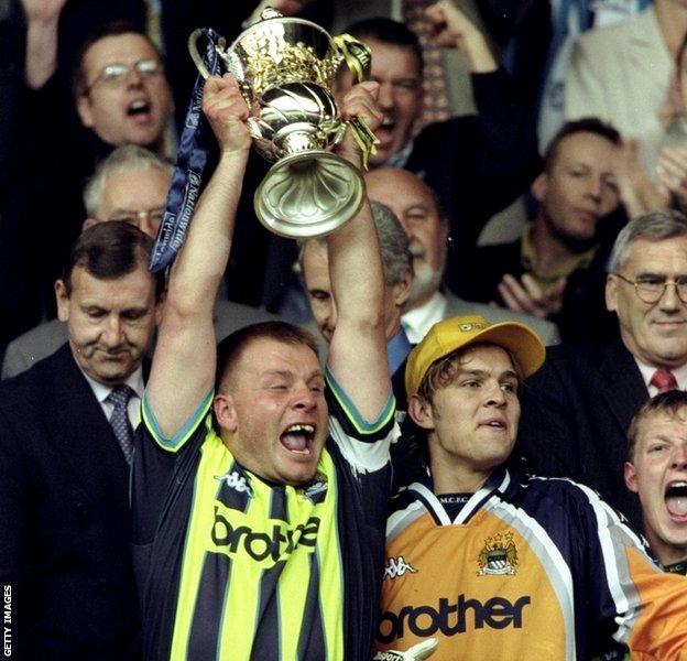 Andy Morrison lifts the trophy as Man City win the League One play-off final