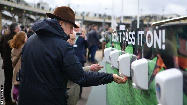 Racegoers using hand sanitiser