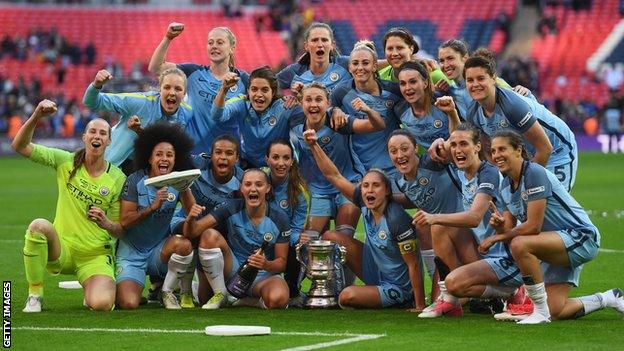 Manchester City Women's team celebrates in front of the Women's FA Cup at Wembley in 2017