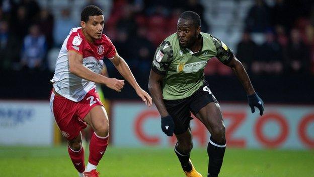 Frank Nouble, of Colchester United, attempts to take the ball around Luther Wildin of Stevenage